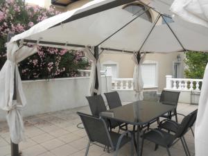 una mesa y sillas bajo una sombrilla blanca en un patio en Villa Sol en Pilar, en Ciudad Quesada