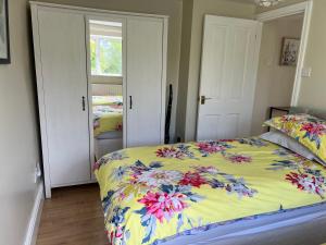 Yew Tree Bungalow, Onneley, Cheshire في كرو: غرفة نوم مع سرير مع لحاف ملون