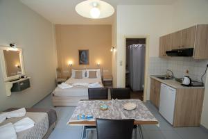a small room with a kitchen and a table with chairs at Rania Studios in Gouves