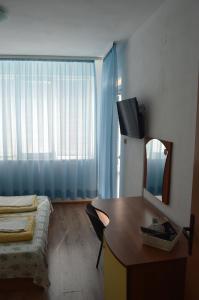 a room with a bed and a desk with a mirror at Yanis in Chernomorets