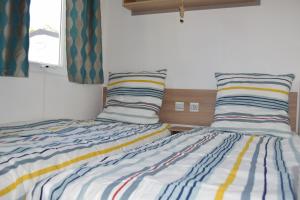 twee bedden naast elkaar in een slaapkamer bij Mobil Home tout confort 6 personnes avec wifi in Onzain