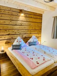 Ce lit se trouve dans un dortoir doté d'un mur en bois. dans l'établissement Bergheimat, à Bad Goisern