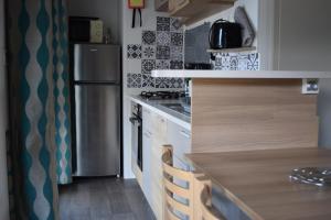 cocina con nevera y encimera en Mobil Home tout confort 6 personnes avec wifi, en Onzain