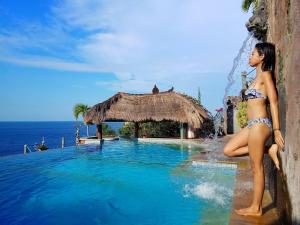 una mujer en bikini parada junto a una piscina en Selang Resort, en Amed