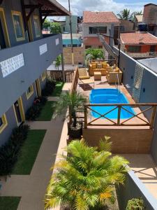 un patio trasero con piscina y una casa en Suíts Praia Bonita em Milagres, en São Miguel dos Milagres