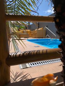 a view of a swimming pool through a palm tree at Suíts Praia Bonita em Milagres in São Miguel dos Milagres