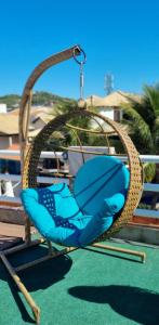 una sedia blu in un'altalena su un parco giochi di PRAIA DOS ANJOS - SUÍTEs ad Arraial do Cabo