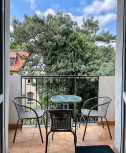 eine Terrasse mit einem Tisch und Stühlen auf dem Balkon in der Unterkunft Turkusowy Sopot in Sopot