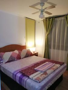 a bedroom with a bed with a ceiling fan at Departamento Portal del Sol Arica in Arica