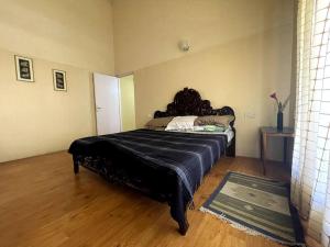 1 dormitorio con 1 cama negra grande en una habitación en Rustic 3-BR Villa w/ Front & Back Yards in the mountains, en Ooty