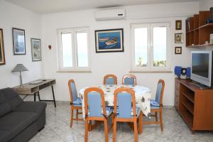 ein Wohnzimmer mit einem Tisch, Stühlen und einem Sofa in der Unterkunft Apartment Frida in Supetar