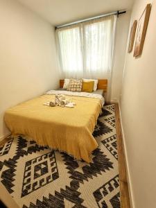 een slaapkamer met een bed, een raam en een tapijt bij Birchwood place in Sarajevo