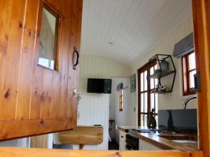 a kitchen with a wooden door and a stove at Hare's Hut in Saint Clement