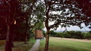 un fienile nel mezzo di un campo con alberi di Hare's Hut a Saint Clement