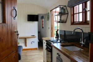 uma cozinha com um lavatório e um fogão forno superior em Hare's Hut em Saint Clement