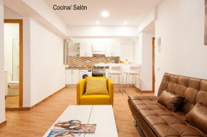 ラスパルマス・デ・グランカナリアにあるKasa Holiday Apartmentのリビングルーム(ソファ、黄色の椅子付)