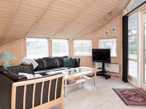 a living room with a black couch and a tv at Holiday home Slagelse XX in Slagelse