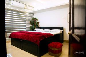 a bedroom with a large bed with a red blanket at ARABIAN HOLIDAY RESORT WITH SWIMMING POOL IN IDUKKI Calvary Mount in Idukki +90 photos