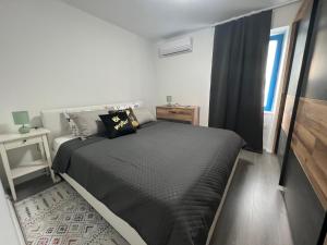 a bedroom with a black bed and a window at Doneto, apartment in private house in Rijeka