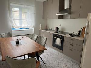 a kitchen with a wooden table and a dining room at Doneto, apartment in private house in Rijeka