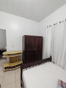 1 dormitorio con 1 cama y armario de madera en Apartamento - Anthurium, en Joinville