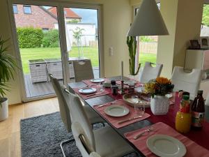 a dining room table with a red tablecloth and white plates at Schönes Privatzimmer Region Hannover in Springe