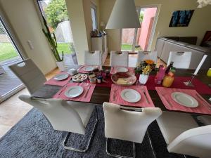a dining room table with white chairs and a red table cloth at Schönes Privatzimmer Region Hannover in Springe +13 photos