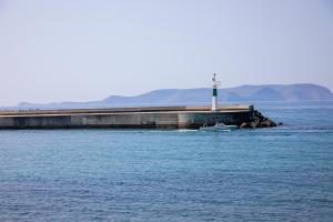 a lighthouse in the middle of a body of water at Rania Studios in Gouves