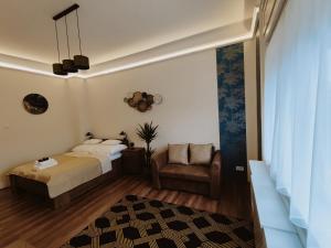 a bedroom with a bed and a chair at Central Palace Apartman in Debrecen