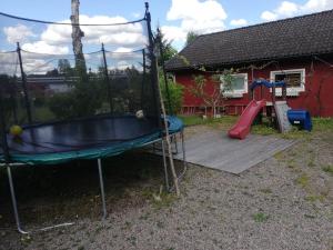 a playground with a slide and a swing at 4Stay Vislanda Sauna in Vislanda