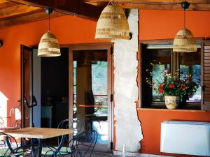 ein Restaurant mit orangefarbenen Wänden sowie einem Tisch und Stühlen in der Unterkunft La Corte degli Ulivi - Albergo Rurale in Tresnuraghes