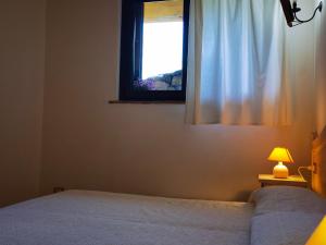 a bedroom with a bed and a window at La Corte degli Ulivi - Albergo Rurale in Tresnuraghes