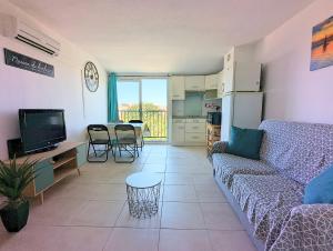 een woonkamer met een bank en een tafel en een keuken bij Appartement proche port et mer avec wifi et climatisation in Cap d'Agde