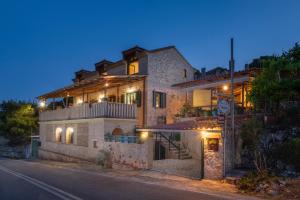 una gran casa de piedra con luces en una calle en Zakynthos Shipwreck Nearby&Easy Parking&Barbecue Patio, en Ágios Nikólaos