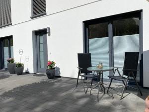 a patio with a table and chairs next to a building at Ferienwohnung Im Dhrontal in Gräfendhron