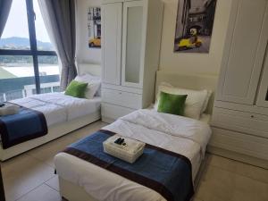 a hotel room with two beds and a window at Mines Astetica Lake View Condo Seri Kembangan v1 in Seri Kembangan