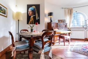 a dining room with a table and a painting of a woman at La Tana delle Stelle B&B di Charme e Relax in Fara in Sabina