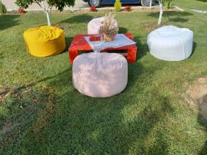 a table and four bean bags on the grass at Vila Islami in Durrës