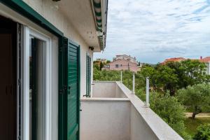a window with a green door on a balcony at Rab Apartment LUCE in Barbat na Rabu +12 photos