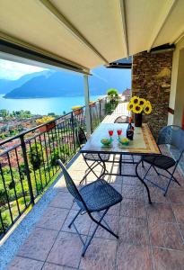 un patio con tavolo e sedie sul balcone. di Sole & Lago-Lake a Maccagno Superiore