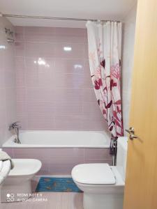 a bathroom with a toilet and a tub and a sink at Apartamento en sol, Ador in Ador +32 photos