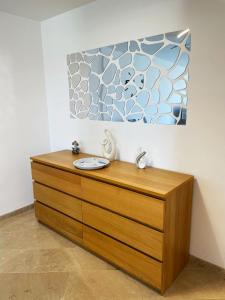 a wooden dresser in a room with a painting on the wall at Apartamento en sol, Ador in Ador