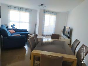 a living room with a table and a blue couch at Apartamento en sol, Ador in Ador