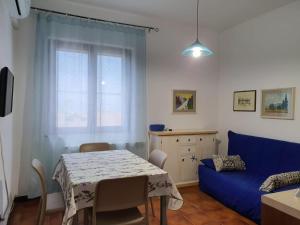 uma sala de estar com uma mesa e um sofá azul em Stella Maris em Santa Teresa Gallura
