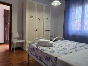 una camera con un letto e una sedia e una finestra di Stella Maris a Santa Teresa di Gallura