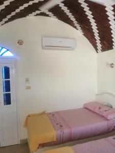 um quarto com uma cama numa parede branca em Roma House em Aswan