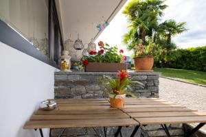 una mesa de madera con flores en el patio en Casa Alice Ascona, appartamento di vacanza., en Ascona