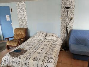 ein Schlafzimmer mit einem Bett, einem Stuhl und einer Lampe in der Unterkunft ferme du sapin in Daillancourt