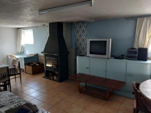 a living room with a tv and a fireplace at ferme du sapin in Daillancourt