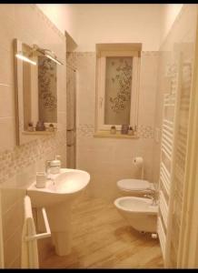 a white bathroom with a sink and a toilet at A' Ches du' Mestr 1 in Montalbano